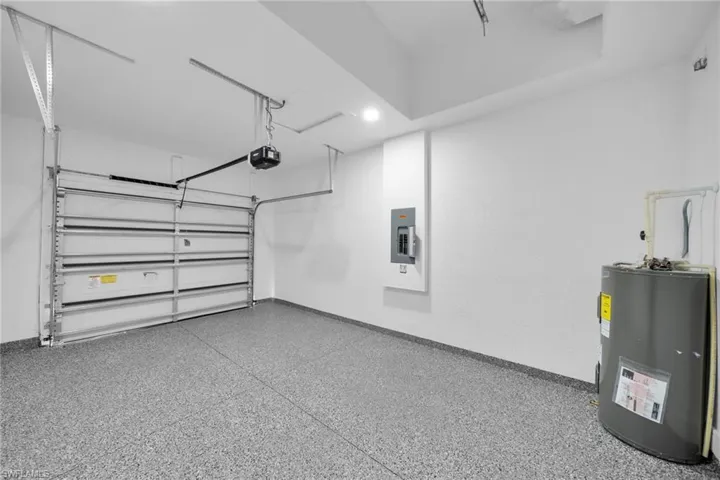 Spacious garage featuring a finished floor coating, automatic garage door opener, and recessed ceiling lighting
