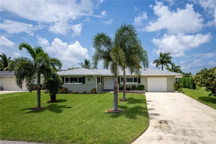 Ranch-style home with a garage and a front lawn