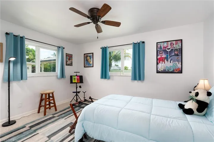 Bedroom featuring carpet flooring, multiple windows, and ceiling fan
