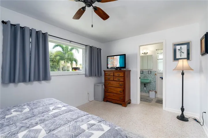 Bedroom featuring sink, ensuite bath, and ceiling fan