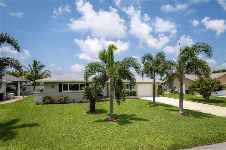 Single story home featuring a garage and a front lawn