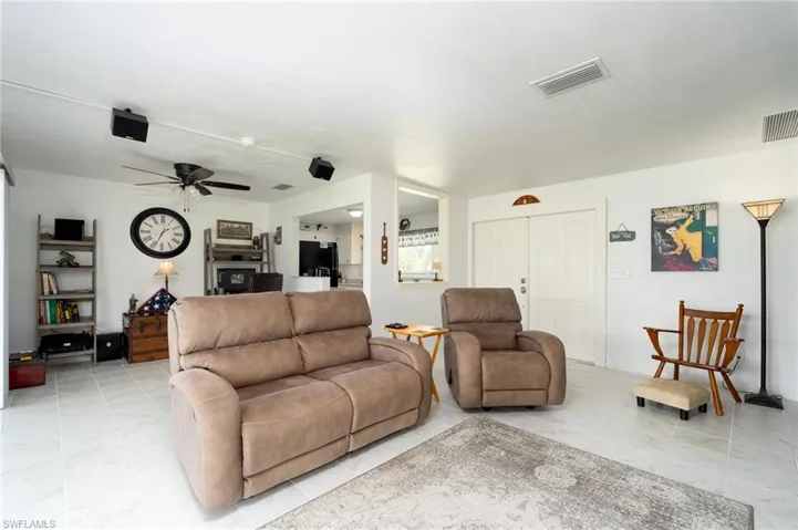 Living room with ceiling fan and light tile patterned floors