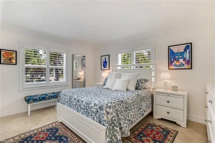 Bedroom with light tile flooring and crown molding