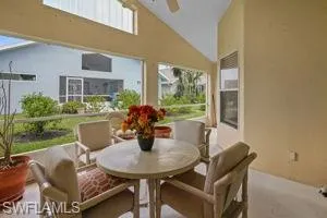 Sunroom / solarium featuring healthy amount of natural light, high vaulted ceiling, and carpet flooring