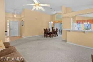 Carpeted living area with baseboards and a ceiling fan