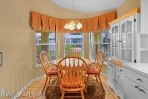 Dining space featuring light tile patterned flooring and a chandelier