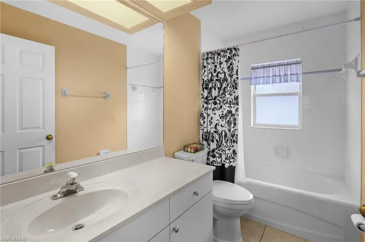 Full bath with vanity, tile patterned flooring, and shower / tub combo with curtain