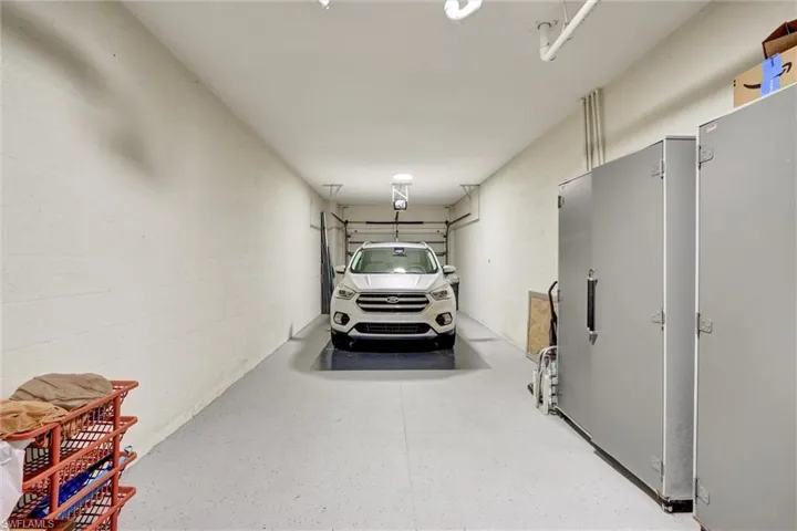 Garage with light gray walls, epoxy flooring, and overhead lighting