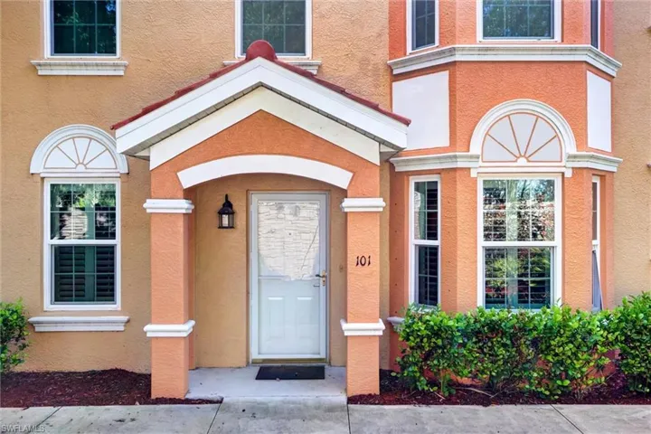 Stucco exterior with decorative trim, bay window, arched entryway, and permanent address numbering