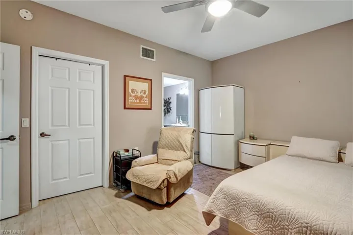 Wood-finish flooring with a ceiling fan and overhead lighting