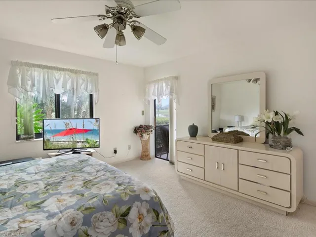 Large windows and glass slider to lanai allow natural light into the room. Views are out to the golf course.