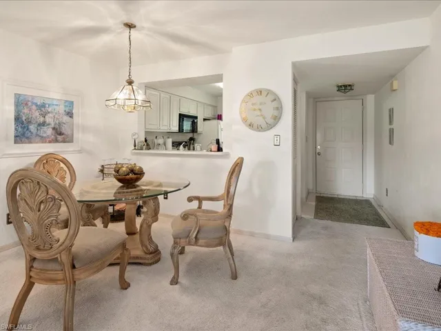 Dining area with wall to wall carpet, decorative chandelier.