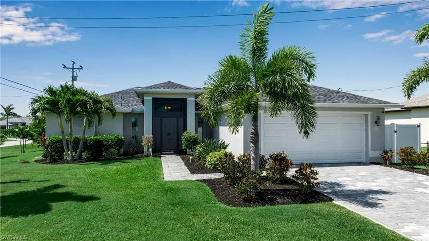 Single story home featuring a garage and a front lawn