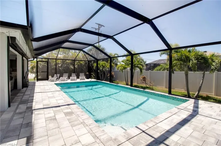 View of swimming pool featuring a patio and a lanai