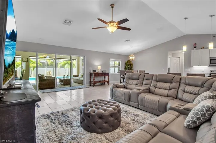 Tiled living room with vaulted ceiling and ceiling fan