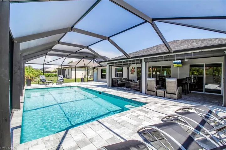 View of swimming pool with a patio and a lanai