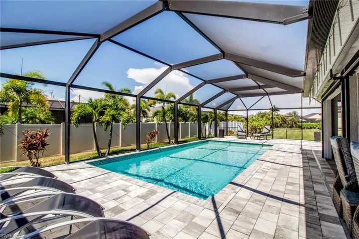 View of swimming pool featuring a patio and glass enclosure