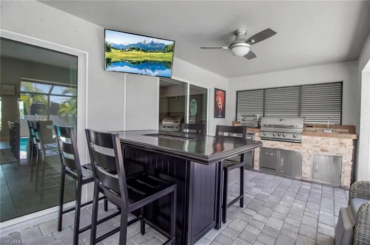 Kitchen with light tile flooring, a breakfast bar area, and ceiling fan