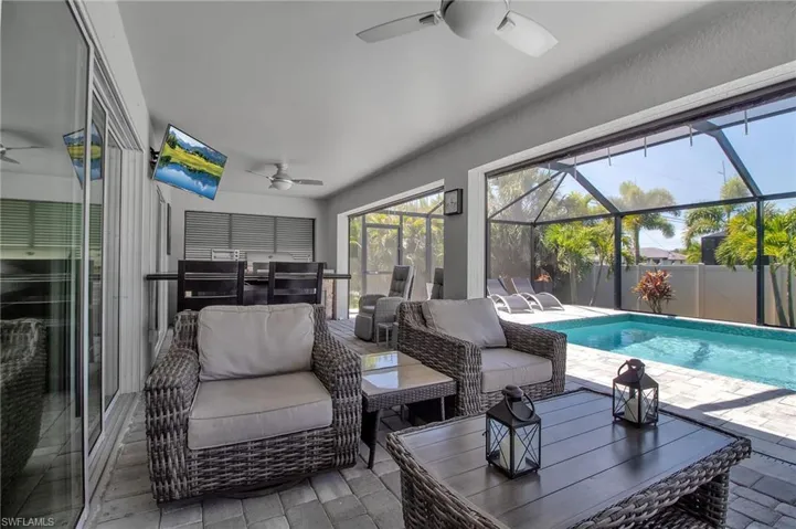 Sunroom with a swimming pool and ceiling fan