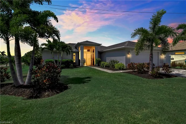 View of front facade featuring a garage and a lawn