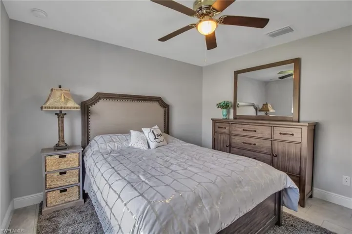 Tiled bedroom featuring ceiling fan