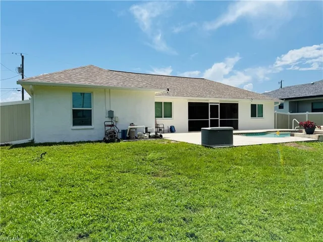 Rear view of property with stucco siding, ashingled roof, and a patio area