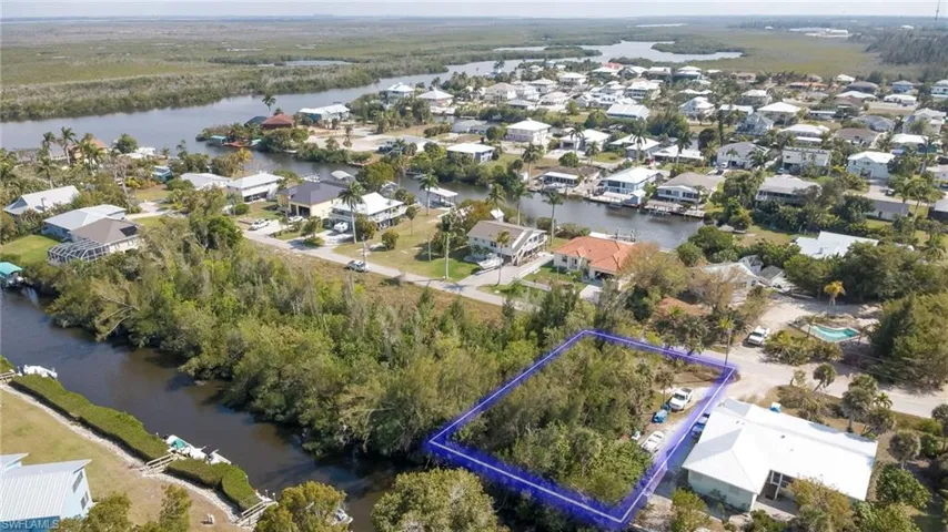 Aerial view of residential area featuring property parcel outlined and a large body of water