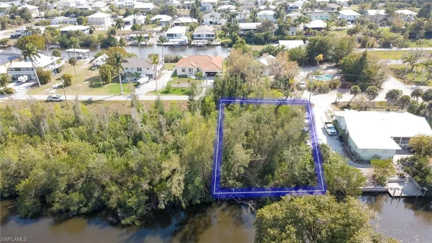Aerial perspective of suburban area featuring a large body of water and property parcel outlined