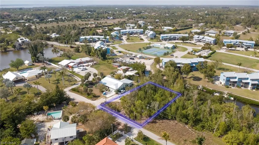 Aerial view of residential area with property parcel outlined and a large body of water