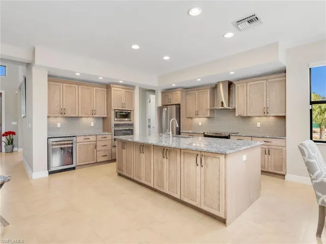Kitchen has Omega cabinetry and a wine cooler.