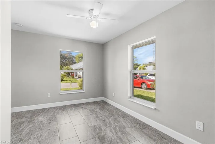 Empty room featuring baseboards and a ceiling fan