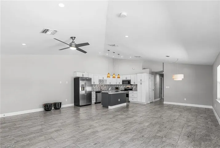 Living area with ceiling fan, high vaulted ceiling, and recessed lighting