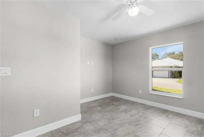 Unfurnished room with baseboards and ceiling fan