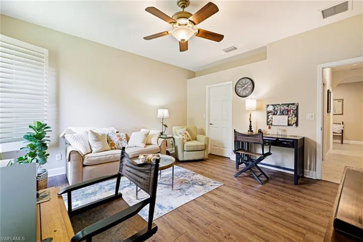 Living room featuring ceiling fan, wood finished floors, and arched walkways