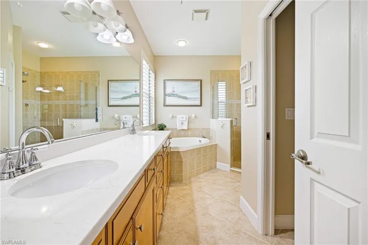 Full bath featuring a shower stall, a bath, tile patterned flooring, and double vanity