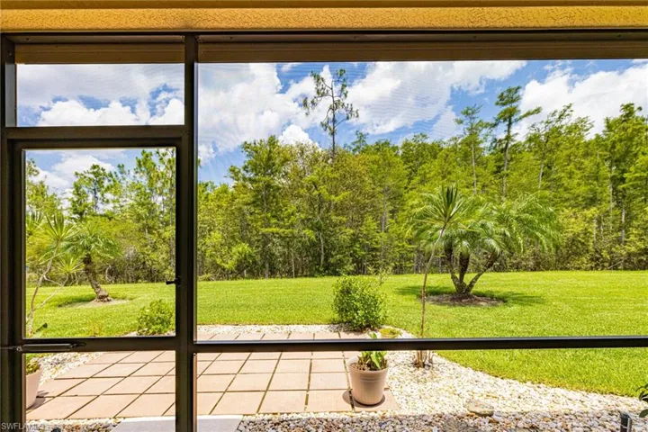 Unfurnished sunroom featuring view of wooded area