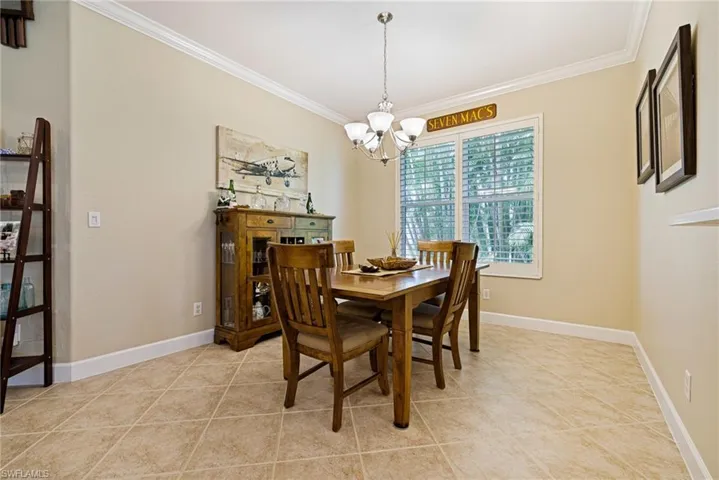 Dining room featuring ornamental molding, a chandelier, and light tile patterned floors