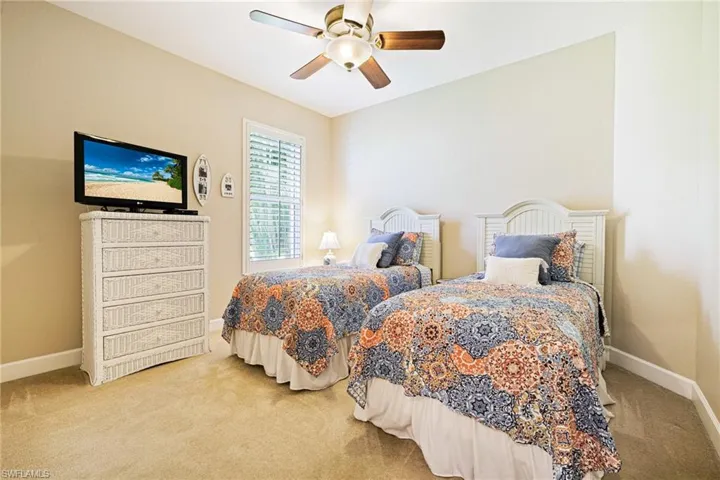 Carpeted bedroom featuring baseboards and a ceiling fan