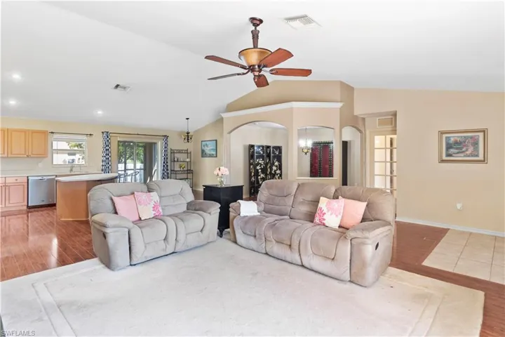 Living room featuring ceiling fan, vaulted ceiling, and light hardwood / wood-style flooring