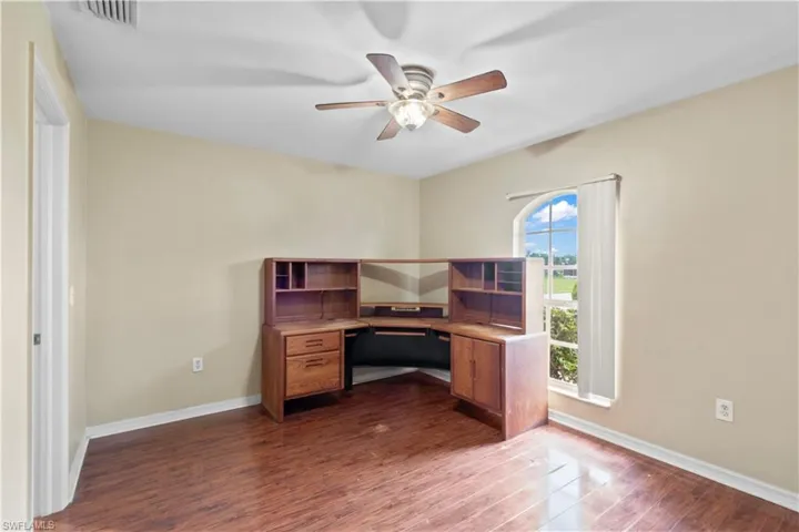 Office area featuring dark hardwood / wood-style flooring and ceiling fan