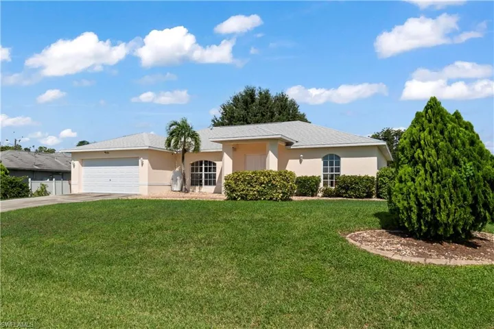 Single story home with a garage and a front yard