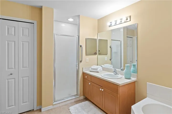 Bathroom with vanity, tile patterned flooring, and shower with separate bathtub