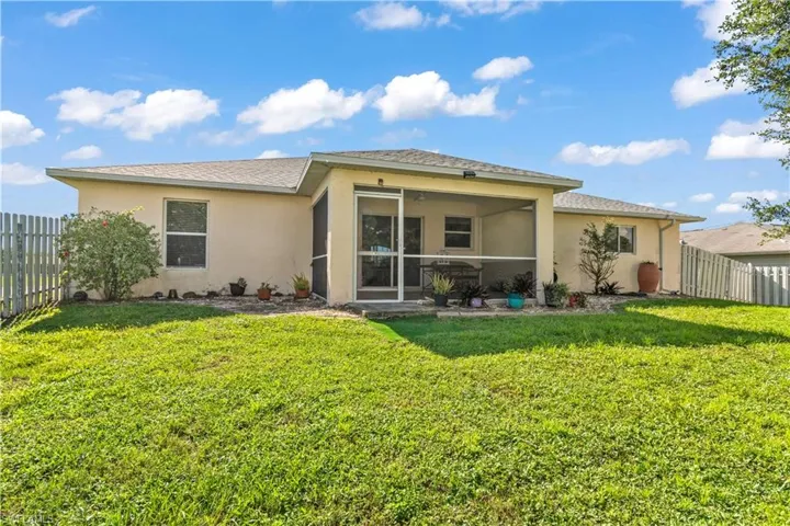 Rear view of house featuring a yard and a sunroom