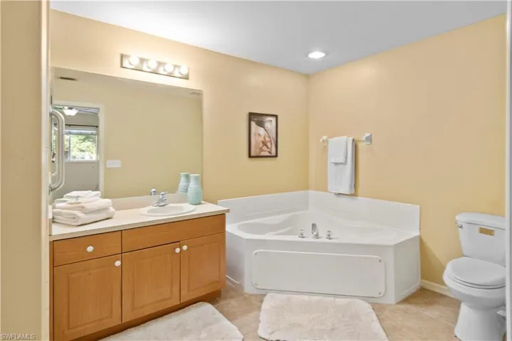 Bathroom with vanity, toilet, a tub, and tile patterned floors