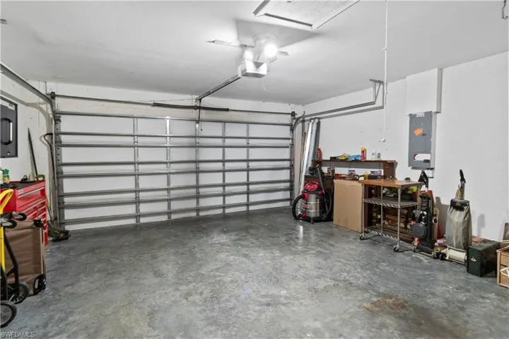 Garage featuring a garage door opener and electric panel