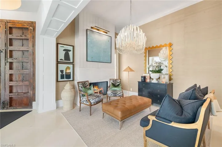 Sitting room featuring baseboards, an inviting chandelier, and tile patterned flooring