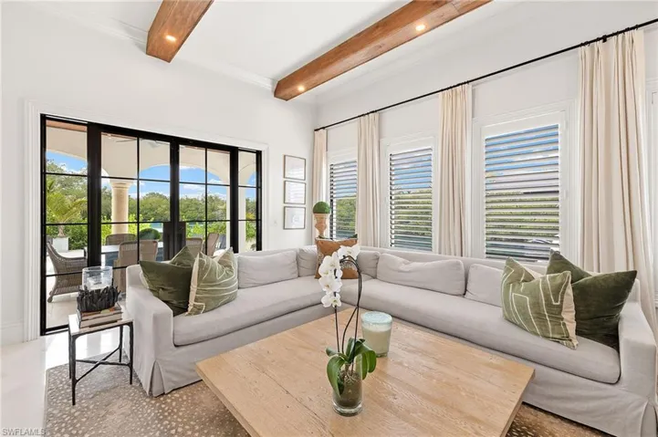 Living room with beam ceiling, recessed lighting, a healthy amount of sunlight, and french doors
