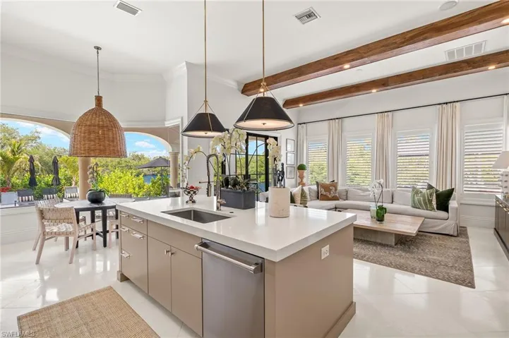 Kitchen with stainless steel dishwasher, light countertops, a sink, and visible vents