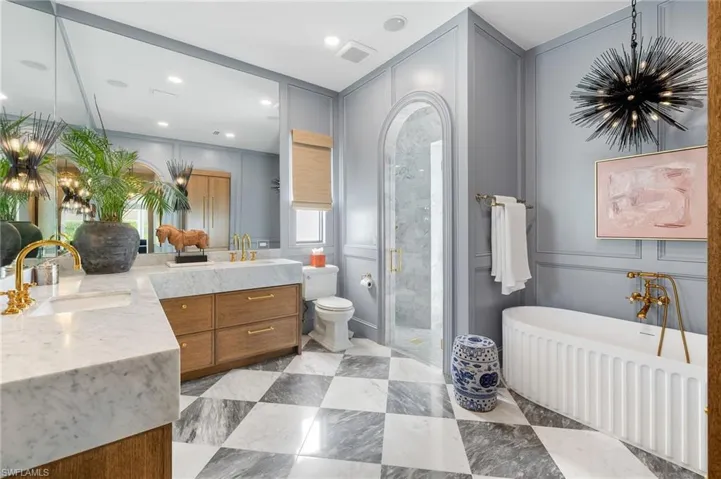 Full bath featuring a sink, double vanity, visible vents, a stall shower, and a notable chandelier