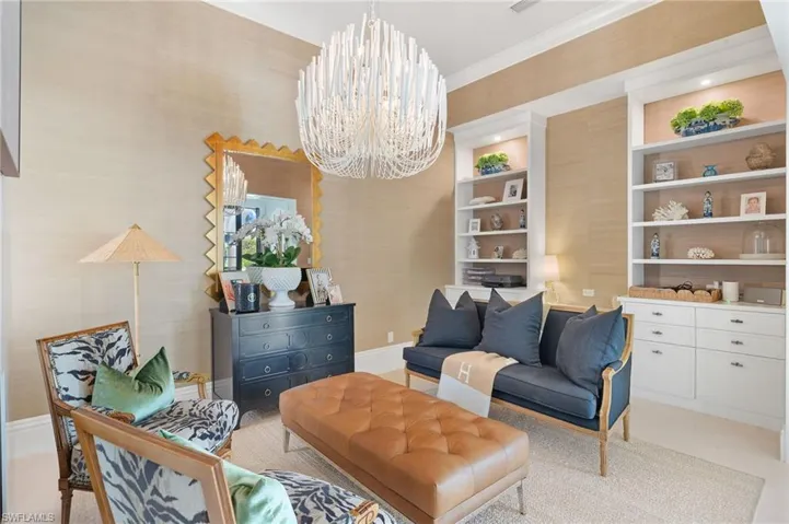 Living area with ornamental molding and a notable chandelier